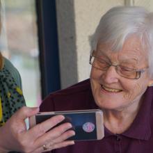 Older woman making video call with help of carer
