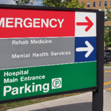 Hospital sign pointing to Emergency, Rehab Medicine, Mental Health Services and Parking