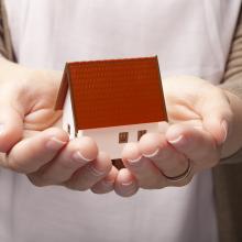Small model house in persons hands