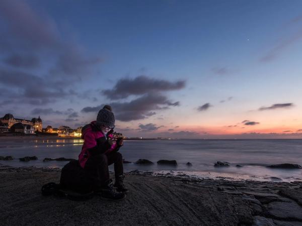 Girl on beach with phone, sunset